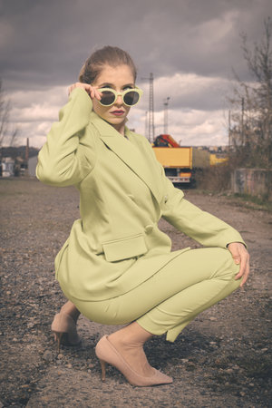 Pretty lady in green costume posing on industrial locationの写真素材
