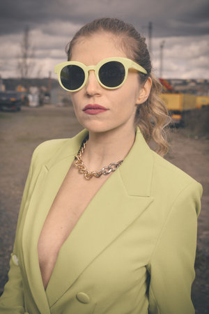 Pretty lady in green costume posing on industrial locationの写真素材