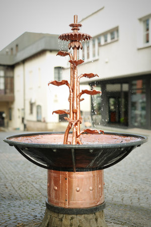 Copper fountain with water running in slow motion footageの写真素材