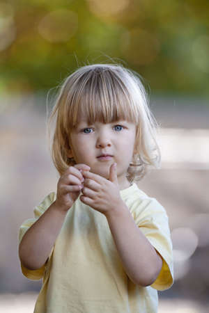 outdoor portrait of a beatiful boy with long blond hairの写真素材