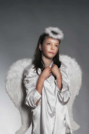 studio portrait of an eleven years old girl dressed as angelの写真素材