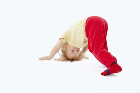 boy with long blond hair trying to stand on his headの写真素材