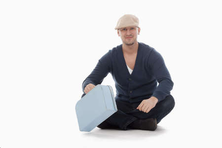 man with a cap and a toy suitcase isolated on whiteの写真素材