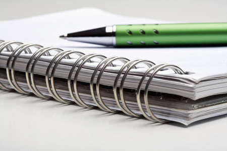 extreme closeup of a ballpoint pen and spiral notebookの写真素材