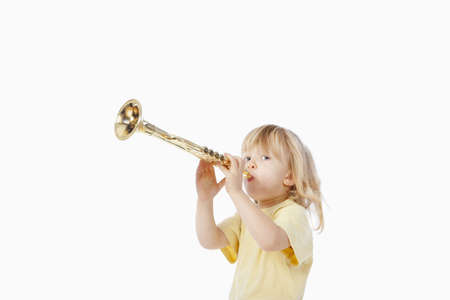 boy with long blond hair playing with toy trumpetの写真素材