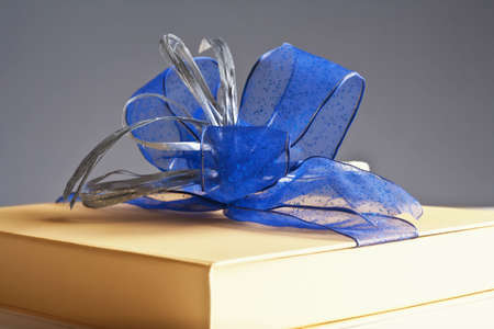 present - luxury gift box decorated with blue ribbon on grey backgroundの写真素材