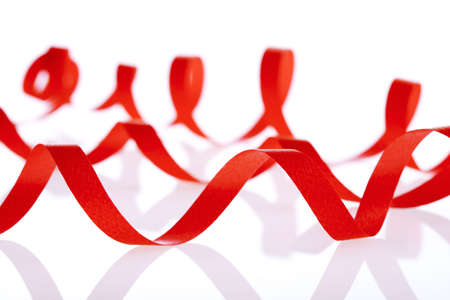 red decorative ribbon in curvy lines isolated on whiteの写真素材