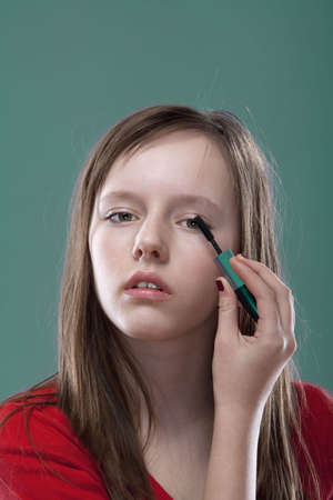 portrait of a pretty eleven years old girl putting on makeupの写真素材