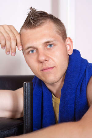 portrait of a young man with towel in modern gymの写真素材