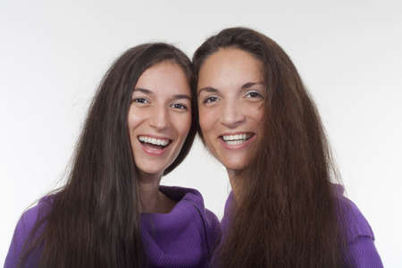 two sisters with very long brown hair standing smilingの写真素材