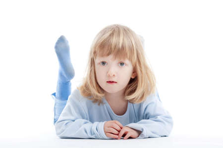 boy with long blond hair on the floor, looking at camera - isolated on whiteの写真素材