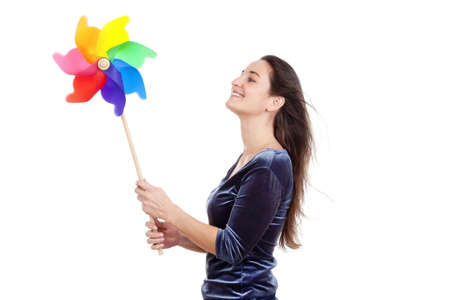 beautiful young woman holding a multicolored pinwheel - isolated on white の写真素材