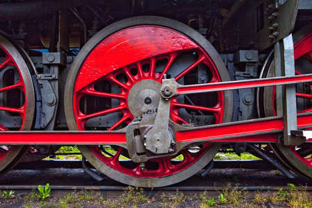red wheels of an old steam locomotive standing on railの写真素材