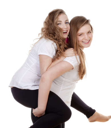 portrait of two young female friends smiling, having fun - isolated on whiteの写真素材
