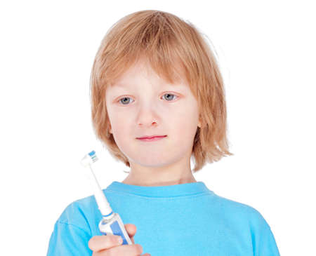 boy with blond hair in blue top brushing his teeth - isolated on whiteの写真素材