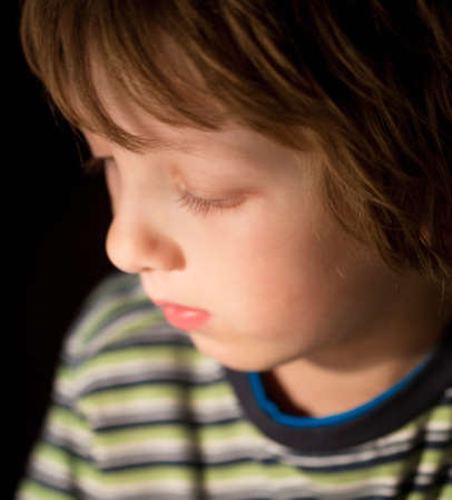 Portrait of a Boy with Blond Hair Looking Downの写真素材