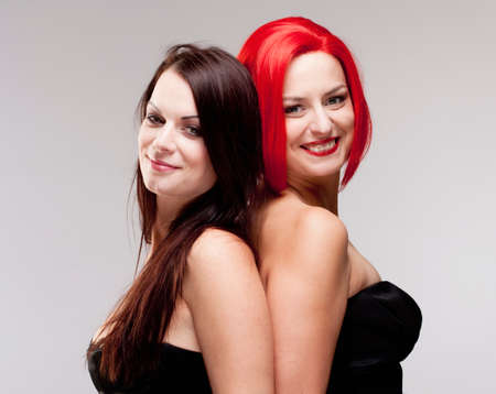 Two Young Female Friends Comparing Wig and Real Hairの写真素材