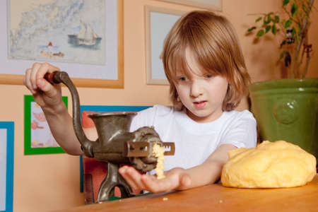 Boy Grinding Flour in the Kitchenの写真素材