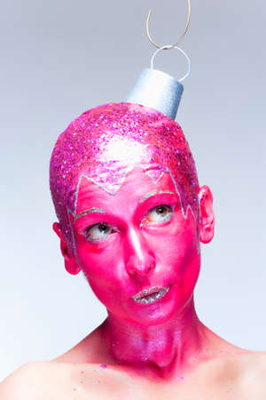 Woman with fantastic makeup posing as a Christmas ornament