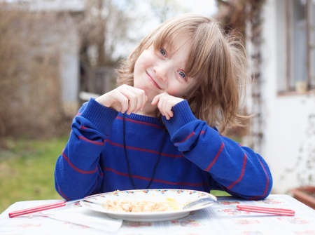 Boy with Blond Hair Eating Outdoors Smilingの写真素材