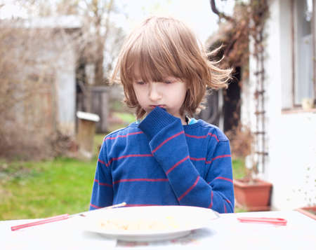 Boy with Blond Hair Looking at Food Thinkingの写真素材