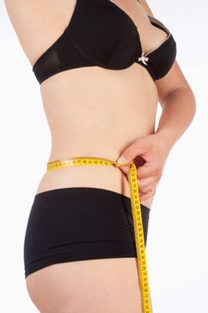 Woman in Black Underwear Measuring her Waistの写真素材