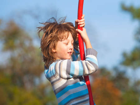 Boy on a Swing in the Playgroundの写真素材