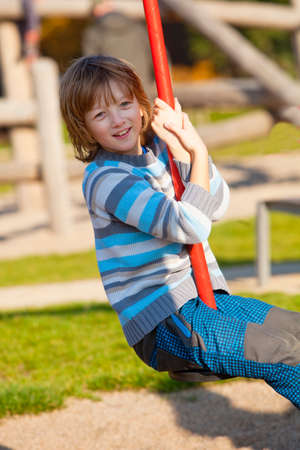 Boy on a Swing in the Playgroundの写真素材