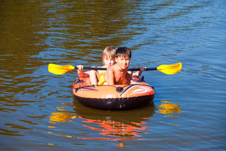 Two Boys Having Fun on Inflatable Rubber Boat in Summer