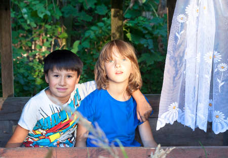 Two Boys Sitting in a Cabin in the Garden Having Fun.の写真素材