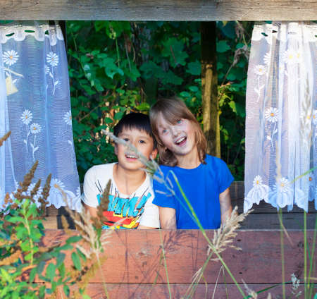 Two Boys Sitting in a Cabin in the Garden Having Fun.の写真素材