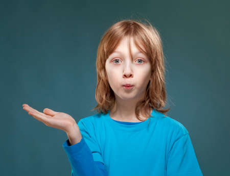Boy in Blue Top Looking with his Palm Outstretched.の写真素材