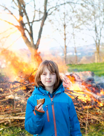 Portrait of a Boy in front of Bonfire Holding a Toast.の写真素材