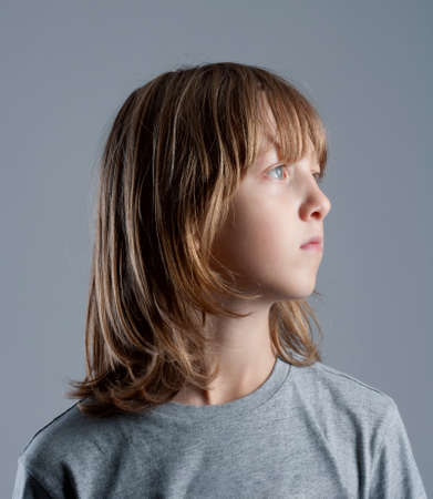 Boy With Long Blond Hair In Blue Top Playing With A Pinwheel