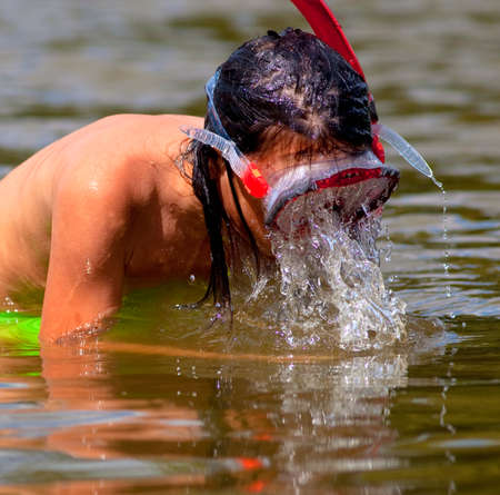 Boy with Long Hair Wearing a Diving Mask and Snorkel.の写真素材