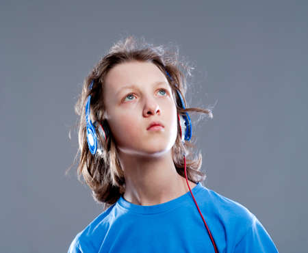 Boy with Brown Hair Listening to Music in Headphones.