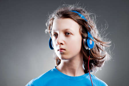 Boy with Brown Hair Listening to Music in Headphones.の写真素材