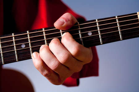 Fingers of a guitar player playing acoustic guitar. の写真素材