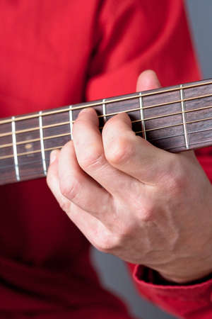 Fingers of a guitar player playing acoustic guitar. の写真素材