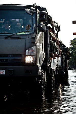 BANGKOK - NOVEMBER 13: A line of military trucks carries officers to help people from the flooded area at Sapan Mai district during the massive flood crisis on November 13, 2011 in Bangkok. のeditorial素材