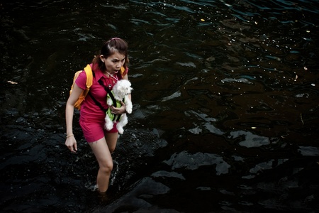 BANGKOK - NOVEMBER 13: An unidentified woman carries a dog to evacuate from the flooded area at Bang Khen road during the massive flood crisis on November 13, 2011 in Bangkok. のeditorial素材