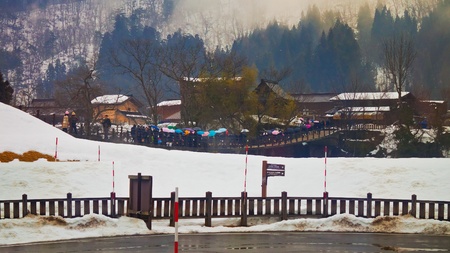 SHIRAKAWA GO, JAPAN - MARCH 28  Crowded people cross the bridge over Shogawa river to the Ogimachi Village, one of Japan s UNESCO world heritage sites on March 28, 2012 in Shirakawa Go, Japan  のeditorial素材