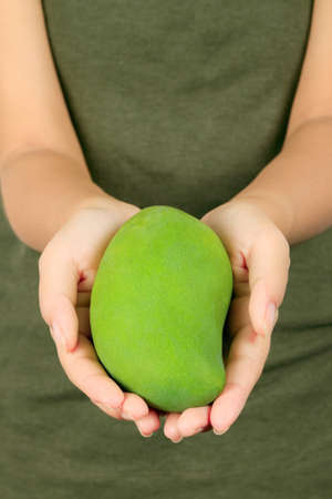 Isolated young asian woman with a mango over white の写真素材