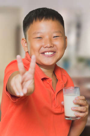 Young Asian boy with a glass of milkの写真素材