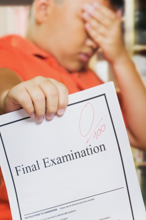 Young asian boy with Zero score on examination paperの写真素材