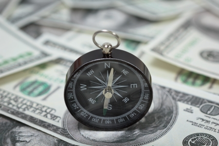 Closeup of a compass placed on U S  Dollar banknotesの写真素材
