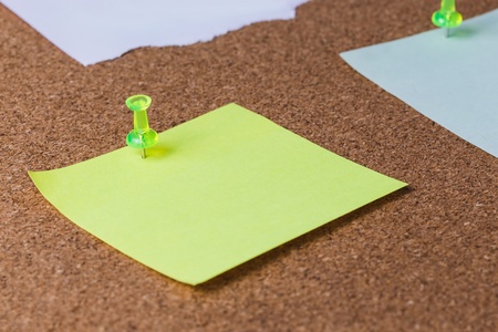 cork board with plastic pins and blank notes