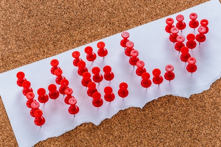Plastic pins form into Help word on blank notepadの写真素材
