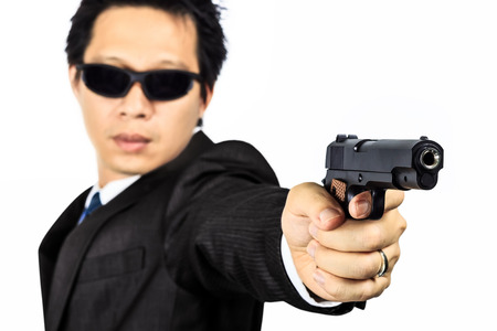 Isolated asian male with a gun on whiteの写真素材
