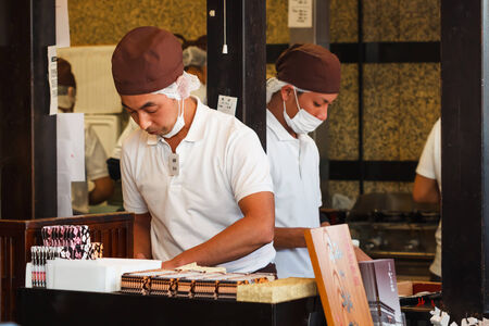 FUKUOKA, JAPAN - NOVEMBER 13: Japanese sweet in Fukuoka, Japan on November 13, 2013. Unidentified male shop keeper calculates money in his shop nearby Dazaifu Tenmanguのeditorial素材